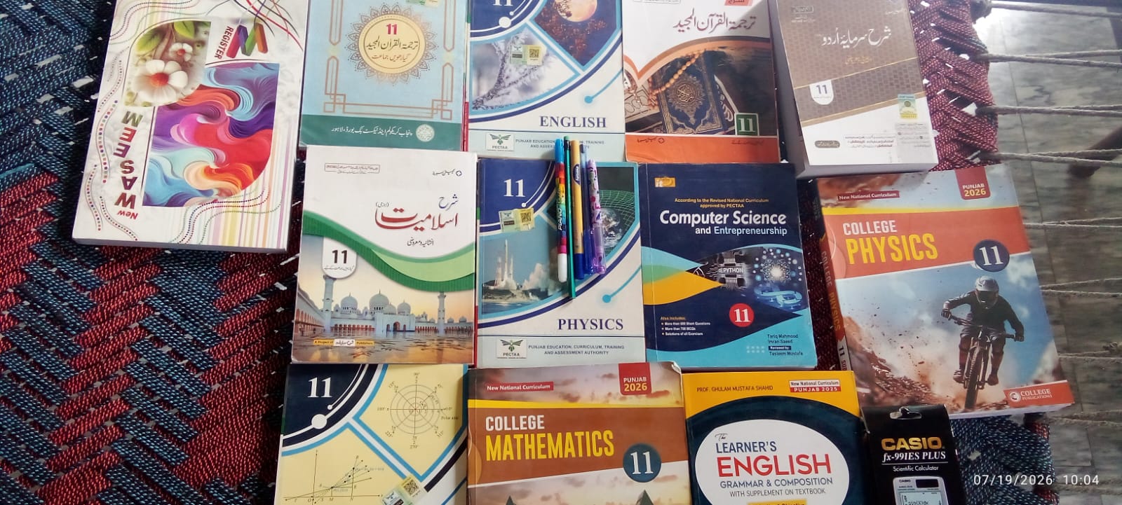 Grade 11 textbooks with pens and a calculator