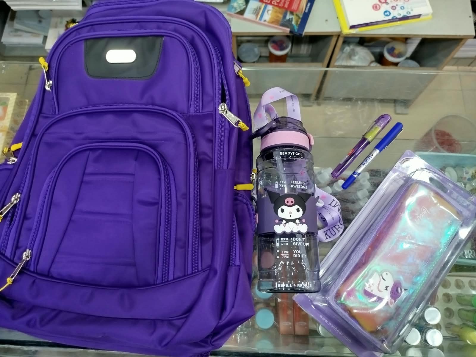 A new school bag with a water bottle, pencil case and pens, bought and ready for a student