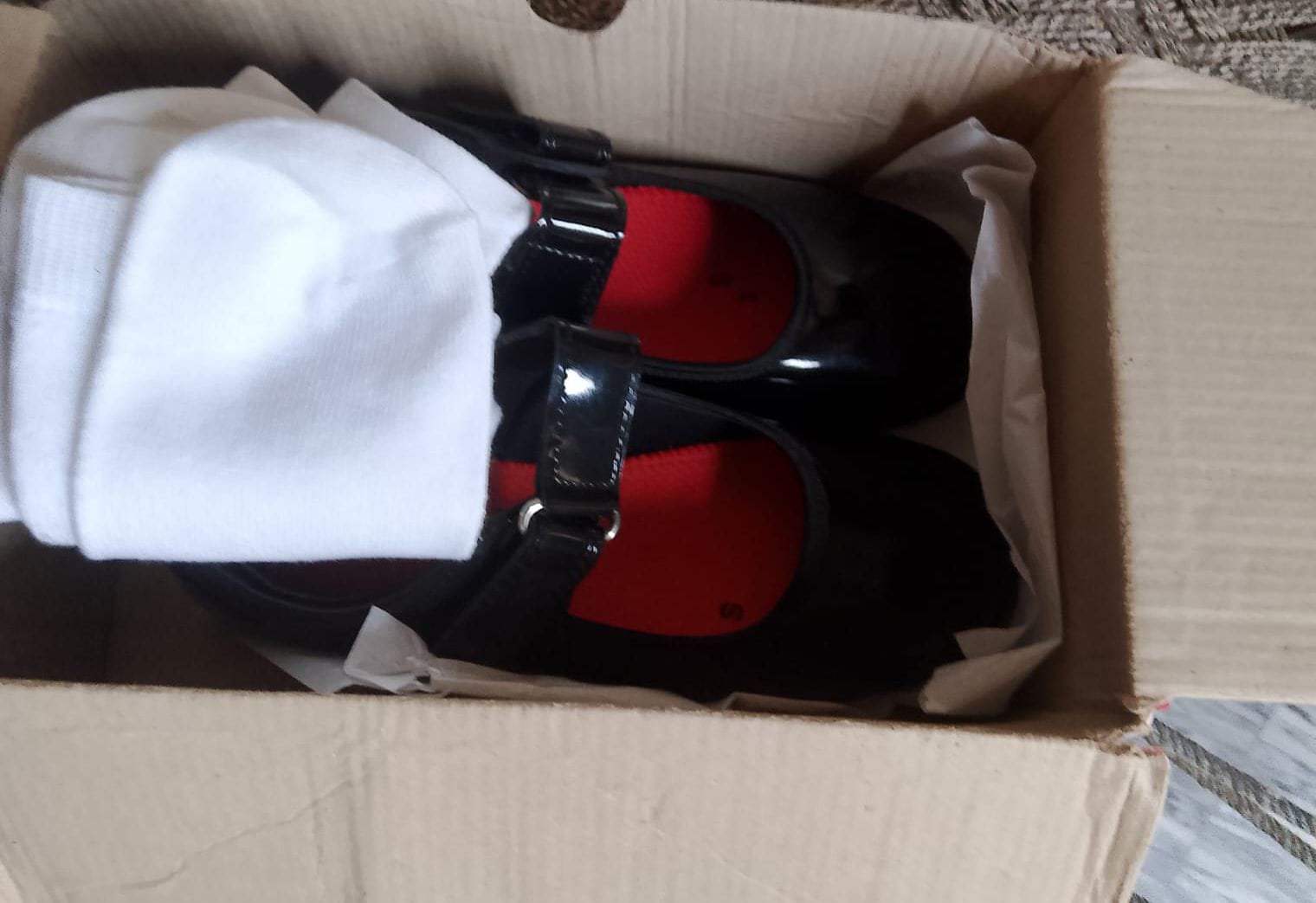 A new pair of school shoes with socks, boxed and ready for a student