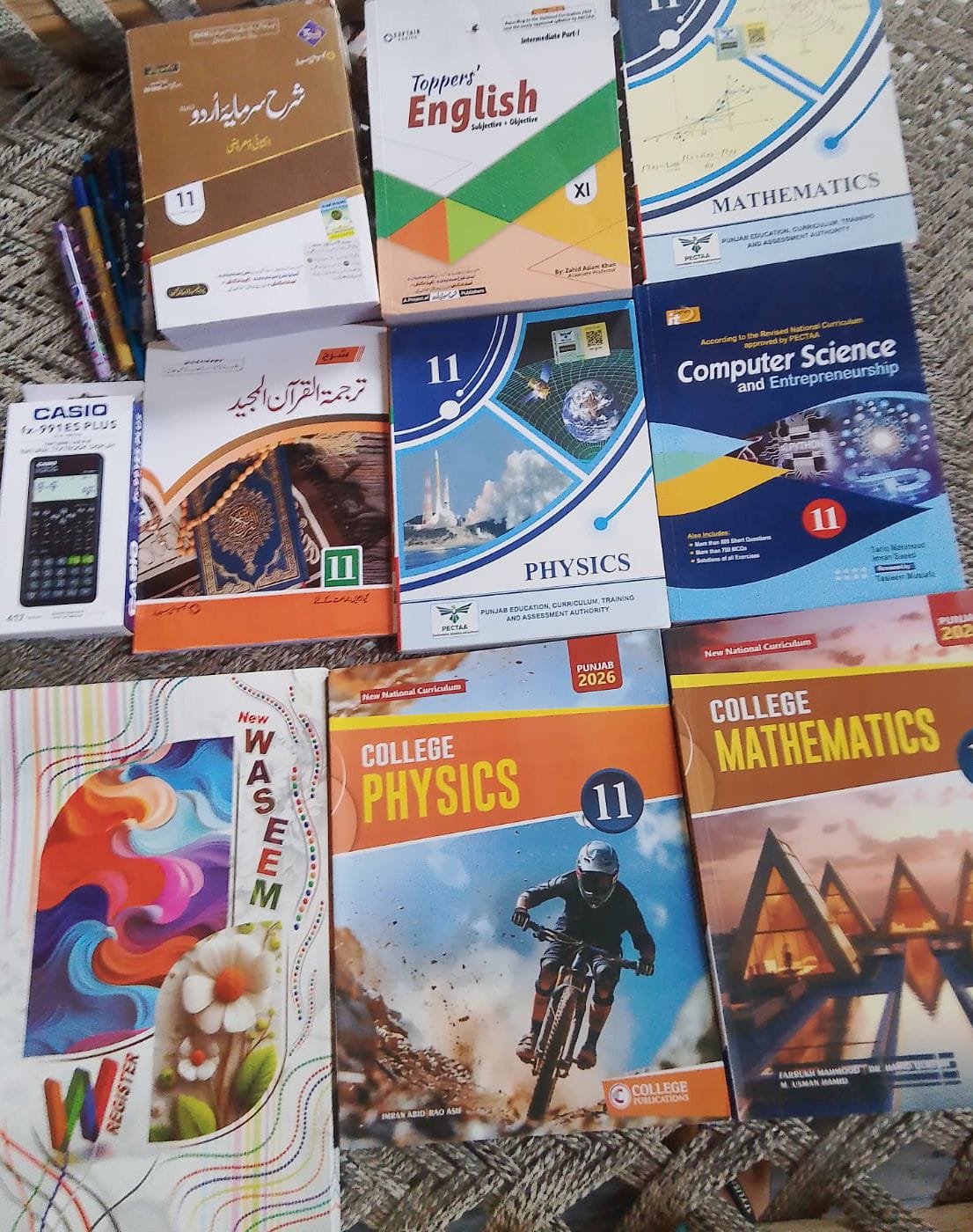 A full Grade 11 book set — Physics, Maths, English, Urdu and Computer Science — with a scientific calculator, register and pens